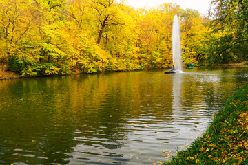 Yellow trees and fountain in autumn park, lake landscape view on Sofievka park, Uman, Ukraine