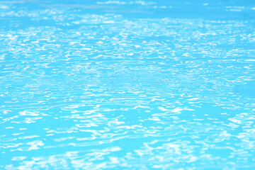 Fototapeta na wymiar Abstract beautiful ripple wave water in swimming pool. Blue (turquoise) wave of water using as wallpaper or background. Blue water with sun reflection. Relaxation and refreshment concept