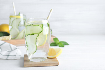 Refreshing water with cucumber, lemon and mint on white table