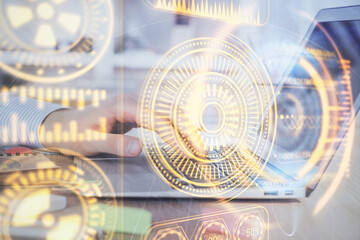 Technology theme hologram with man working on computer on background. High tech concept. Double exposure.