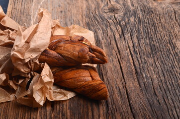 Dried melons in a paper bag, close-up, on a wooden background.