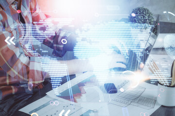 Double exposure of world map hologram with man working on computer on background. Concept of worldwideweb.