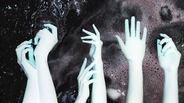 Psychedelic animation. Halloween party. Blue alien hands postures on dark glitter bubble fluid ink flow motion abstract background double exposure. Negative effect. Mystic occult. Fantasy galaxy.