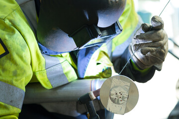 man with a welding mask welding something together