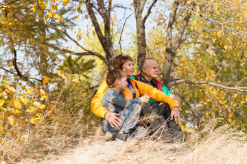 grandparents with their grandson spend time together in nature in the fall