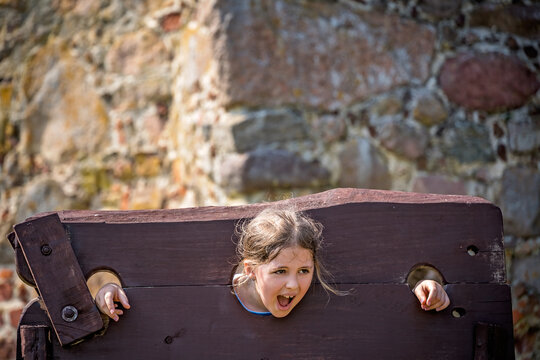 Closeup of a child trapped in a medieval torture device