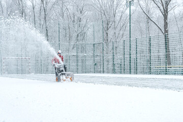 Clearing snow on the playground during a snowfall in winter.