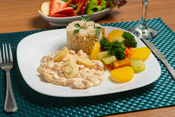 Delicious healthy food with chicken stroganoff with rice and potatoes vegetables on the plate.