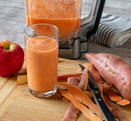Fruit vegetable smoothie with apples and sweet potatoes in a glass and blender