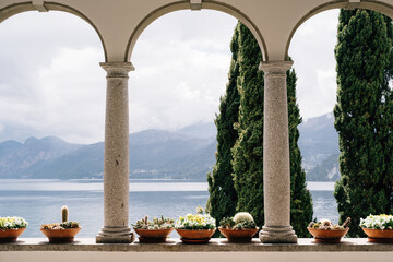 Flower pots with succulents in arches with columns overlooking Lake Como in Italy.