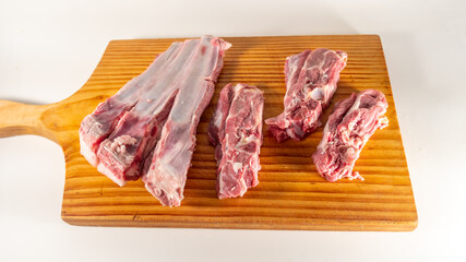 Mutton ribs, raw, on a wooden cutting board