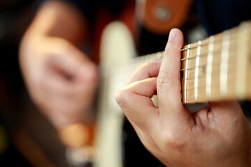 close up hand young man playing electric guitar at recording studio rehearsal base. rock music band.