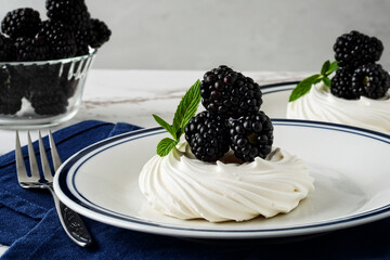 blackberry meringue nest with mint and a blue napkin