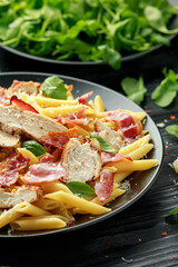 Chicken, bacon Penne pasta with parmesan cheese and basil. healthy food.