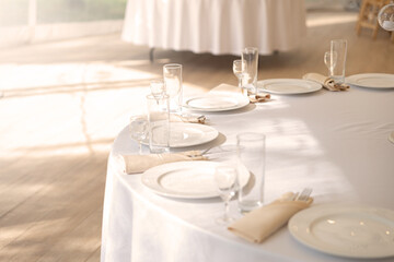 Table setting element empty plates with cutlery on white tablecloth.