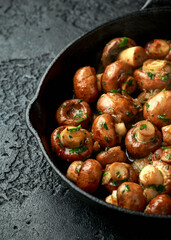 Fried mushrooms with onion and garlic in iron cast pan