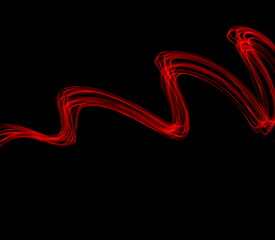 Long exposure photograph of neon colour in an abstract swirl, parallel lines pattern against a black background. Light painting photography.