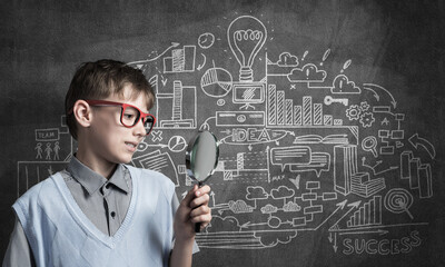 Curious school boy with magnifier