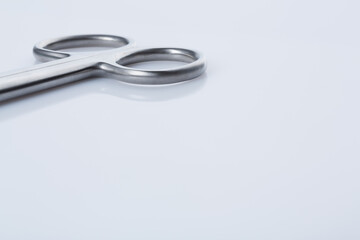 surgical scissor handle in left upper corner upon white background