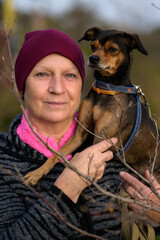 Aged woman with her dog. Selective focus.