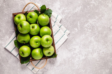 Ripe green apples in wooden box.