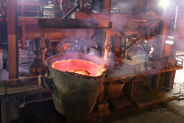 View of the large melting pot with molten metal in the factory.