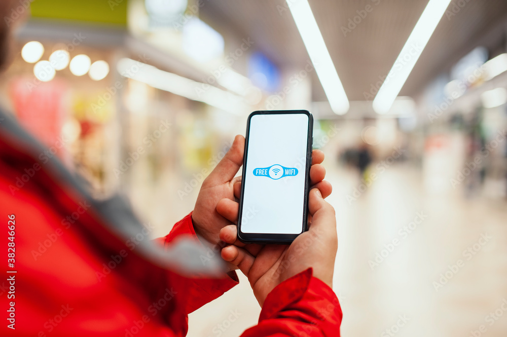 Aufkleber man holds a mockup of a smartphone with an icon on a white screen background. free internet in the s