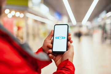 Man holds a mockup of a smartphone with an icon on a white screen background. Free internet in the supermarket.