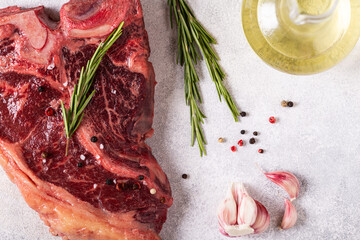 Fresh raw t-bone steak on light stone background