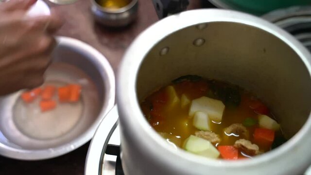 Freshly Cut Potatoes Placed On The Pot Of Pressure Cooker With Other Ingredients Of A Dish. - Wide Shot