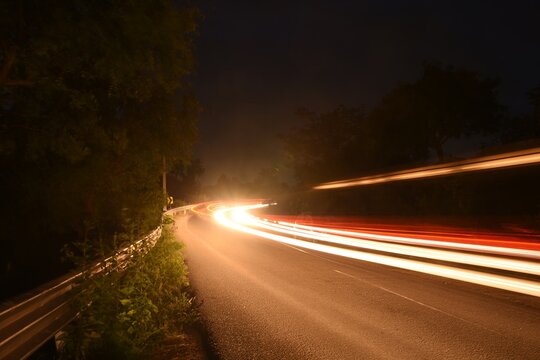 Light trail image of vehicles passing through forest near Manchanabele Dam