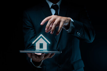 Businessman using tablet with home icon hologram effect.