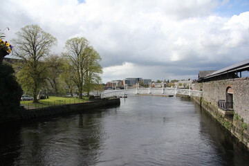 Fototapeta na wymiar White iron bridge crossing the river in the town of Limerick, Ireland