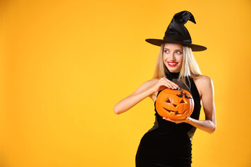 Beautiful woman in witch costume with jack o'lantern on yellow background, space for text....