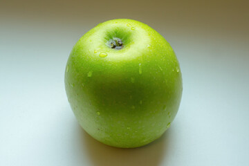 Green wet apple on white background.