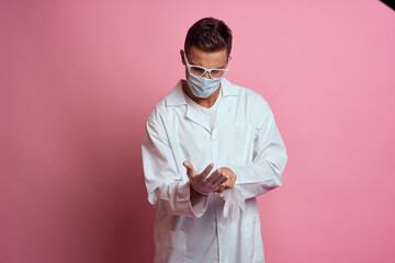 doctor in medical gloves with face mask on pink background cropped view