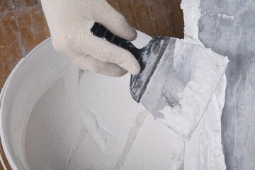 on a large spatula apply a mixture for sealing cracks
