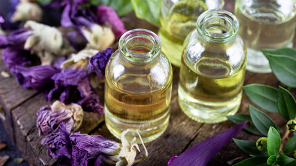 A bottle of common mallow essential oil with dried flowers. Dried herbs with essential oils for aromatherapy treatment. 