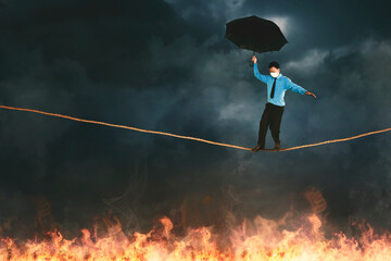 Businessman wear mask while walk on rope over fire - Powered by Adobe