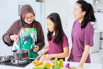 Child cooking with her mother and grandmother
