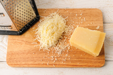 Wedge of traditional italian hard cheese Grana Padano or Parmesan, grated cheese and stainless...