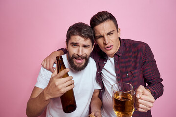 Two men drink beer friendship drunk alcohol lifestyle pink background