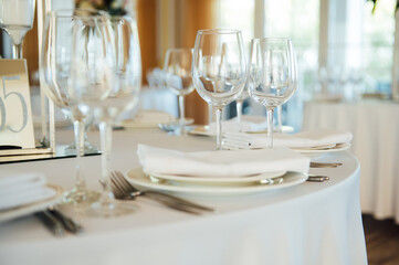 Luxurious restaurant. Luxurious interior, white tables, serving dishes and glasses for guests