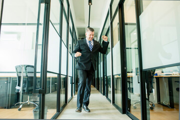 Fototapeta premium Happy male manager dancing in the office corridor