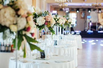 A beautiful vase of flowers on a table in a luxury restaurant. Wedding decorations
