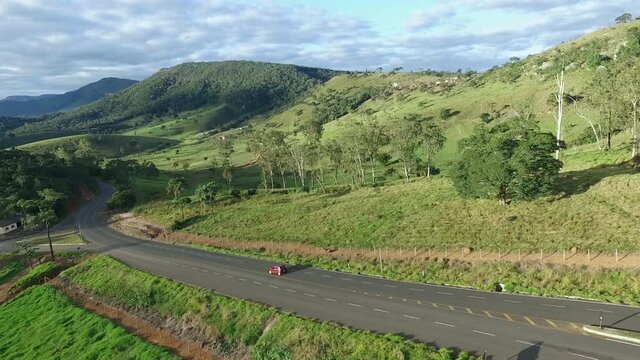 Aerial, pov, a red car on a steep, scenic route, Brazil