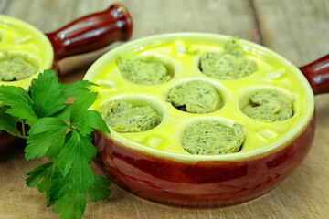 cassolette d'escargots sur une table en bois