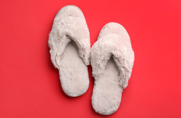 Fototapeta na wymiar Pair of stylish soft slippers on red background, flat lay