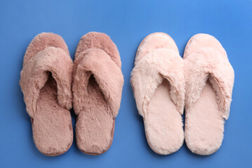 Different stylish soft slippers on blue background, flat lay