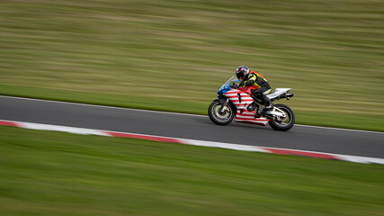 Fototapeta premium A panning shot of a racing bike cornering as it circuits a track.